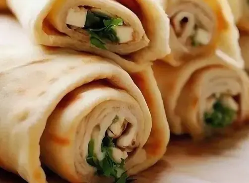 Хрустящие сырные рулетики с брынзой и помидорами на Новый год: легкая закуска за 30 минут